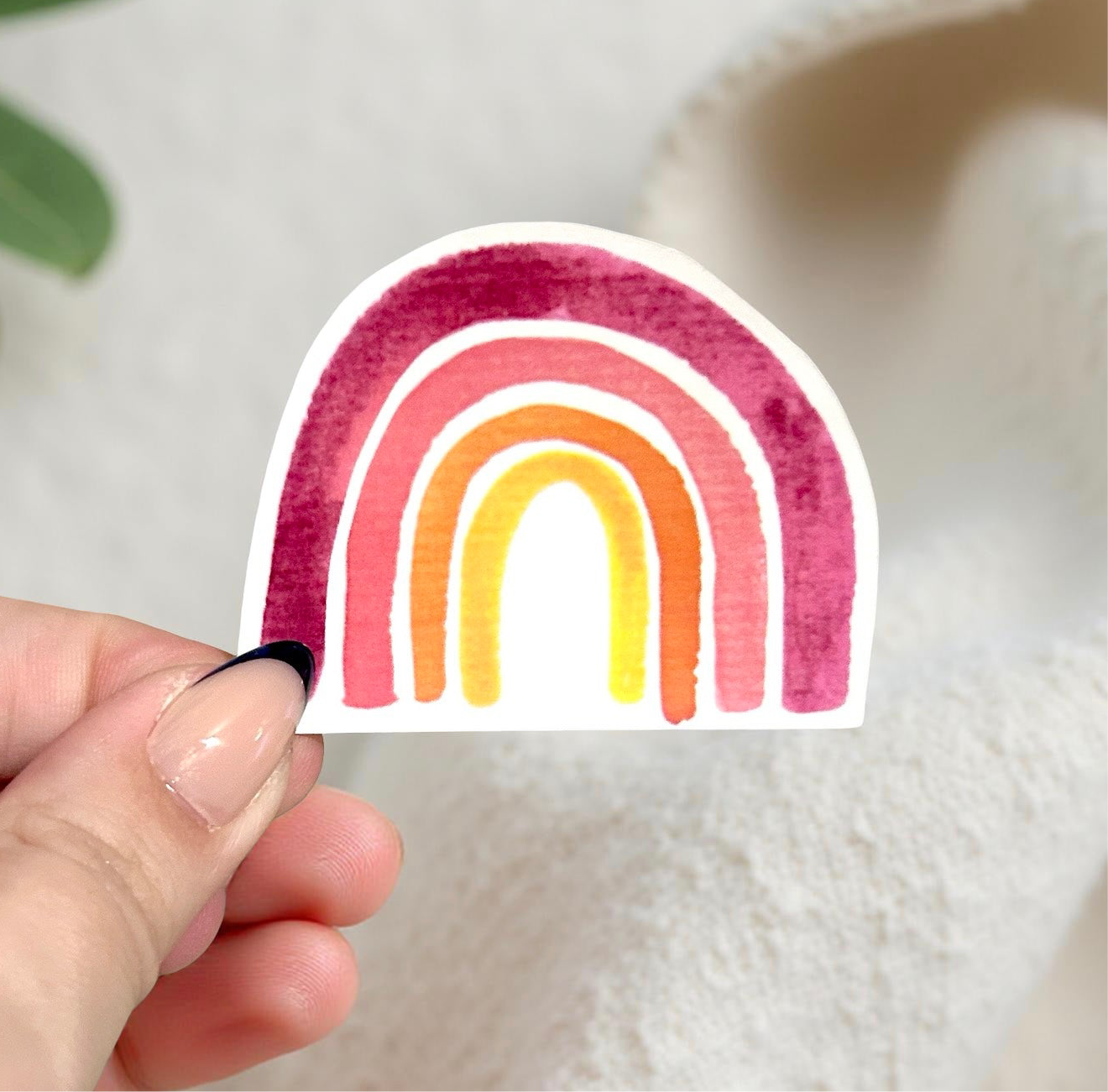 Hand holding watercolor rainbow sticker