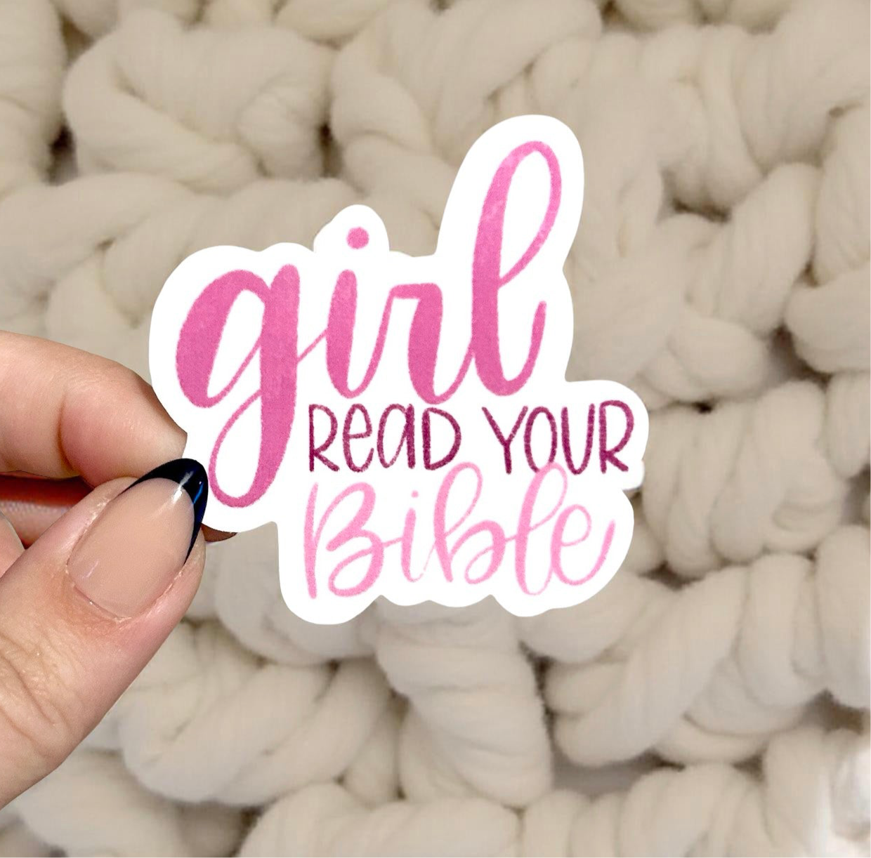 Hand holding sticker that says girl read your Bible