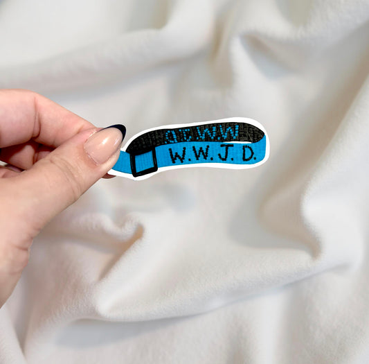 Hand holding sticker of a wwjd bracelet on beige background 