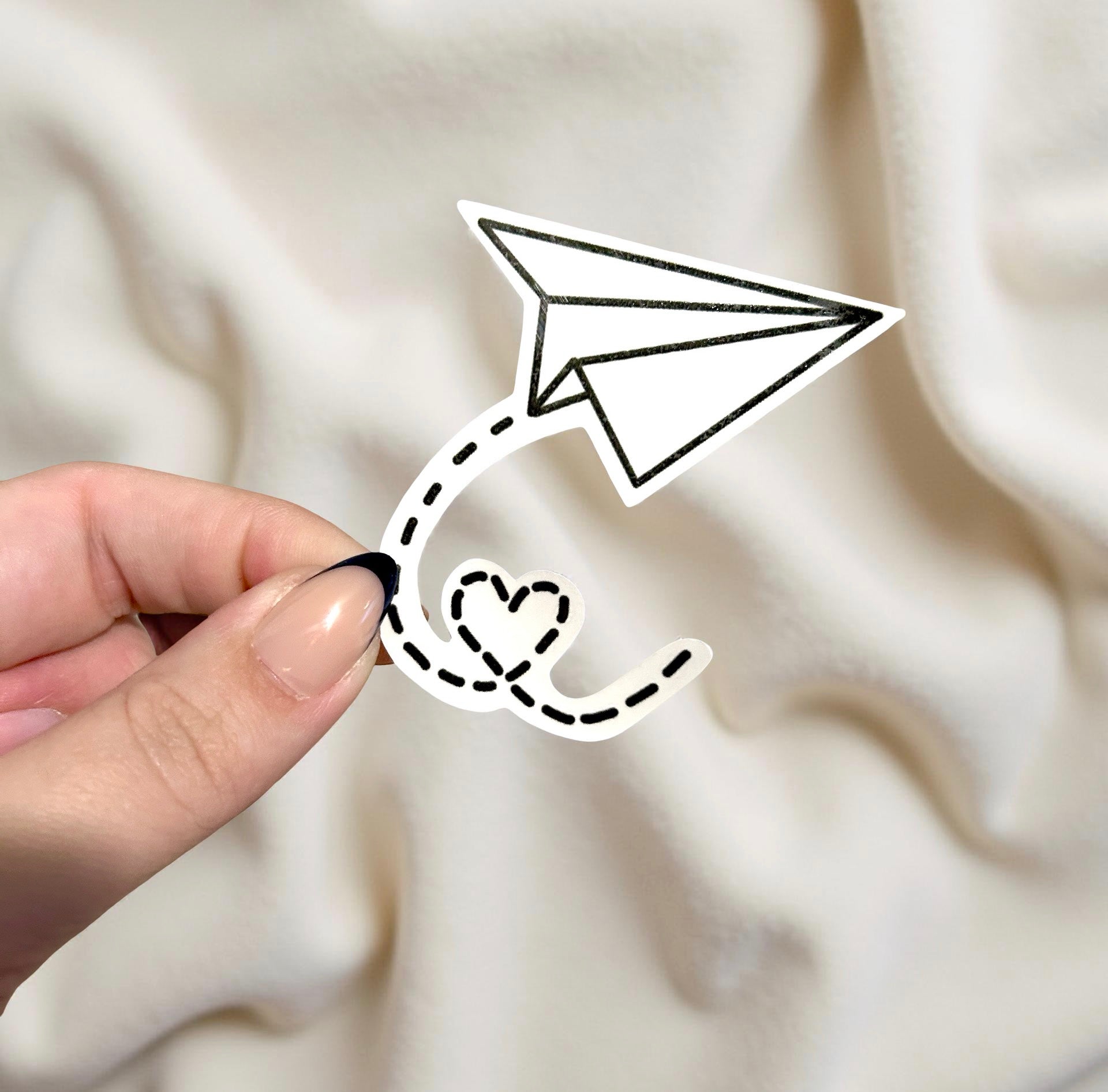 Paper airplane sticker held by hand