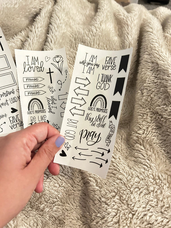 hand holding sheet of clear bible stickers