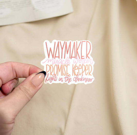 hand holding sticker with the lyrics to waymaker written in pink and orange
